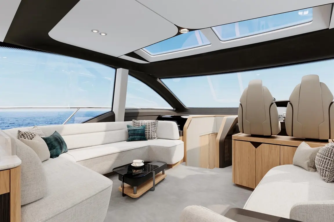 Luxurious yacht interior featuring sleek couches, a coffee table, and panoramic windows revealing a sea view.